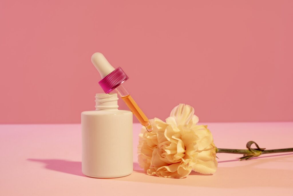 Dermatology skincare bottle with dropper on a pink background