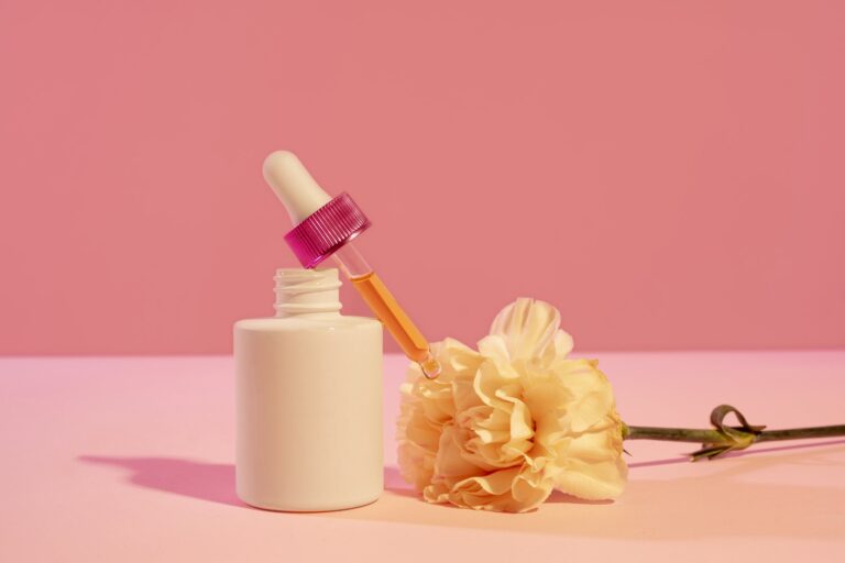 Dermatology skincare bottle with dropper on a pink background